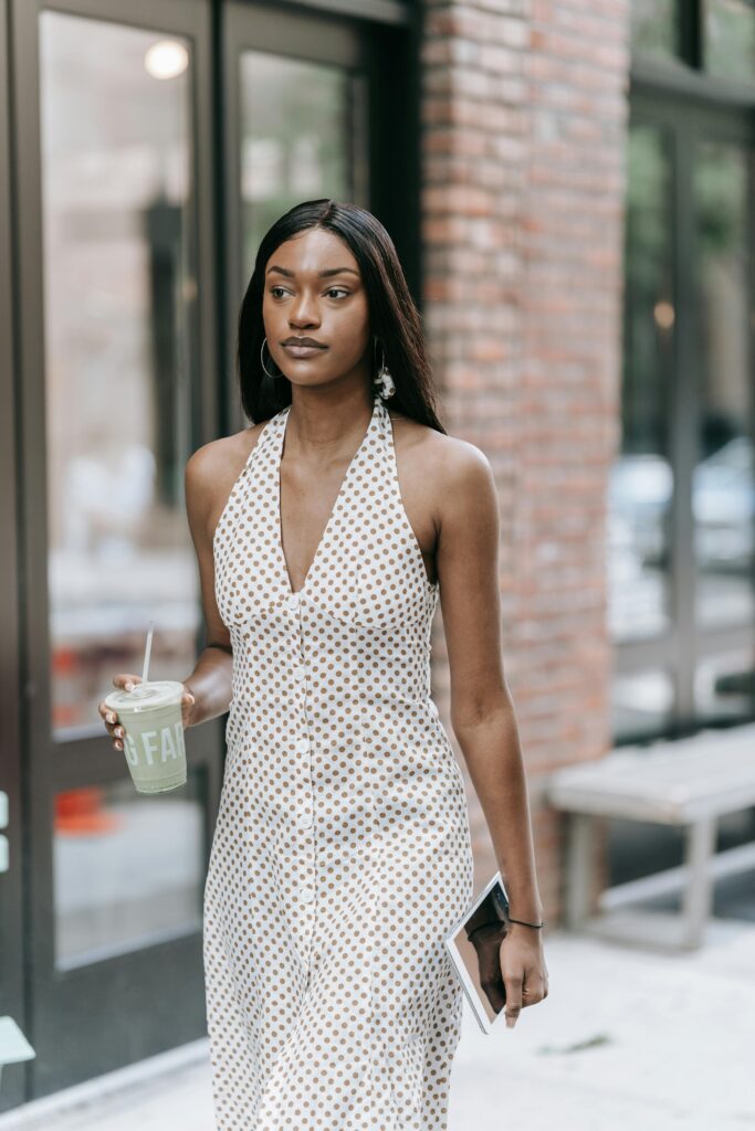 Photo of a woman walking down the street wearing a polka dot dress