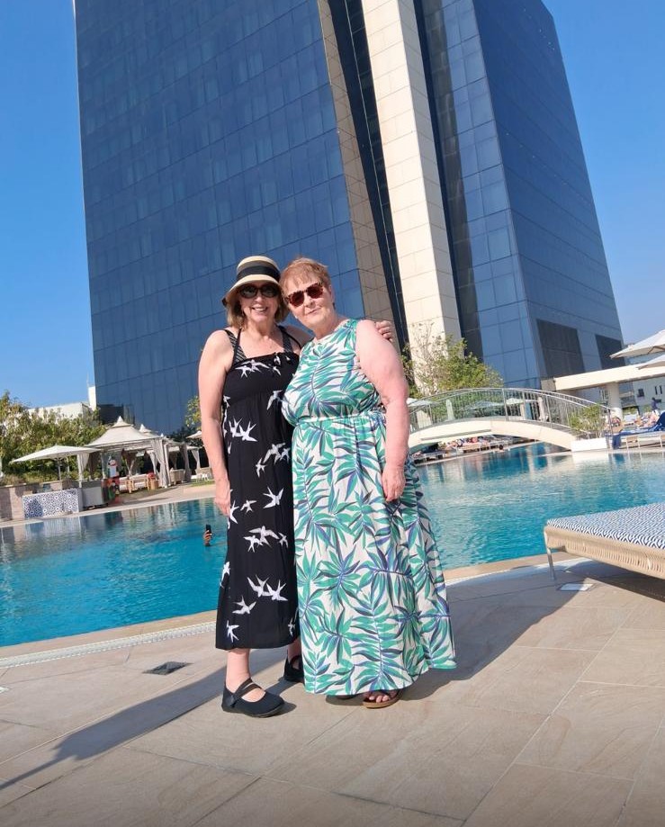 Lynne and Denise pictures in front of a pool on their Dubai holiday before the war broke out